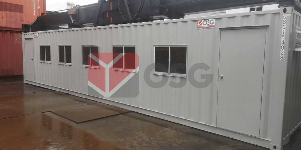 A gray shipping container with multiple windows and doors.