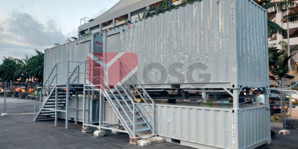 Industrial shipping containers with stairs, set up outdoors.