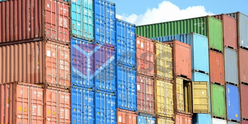 Colorful shipping containers stacked against a blue sky.