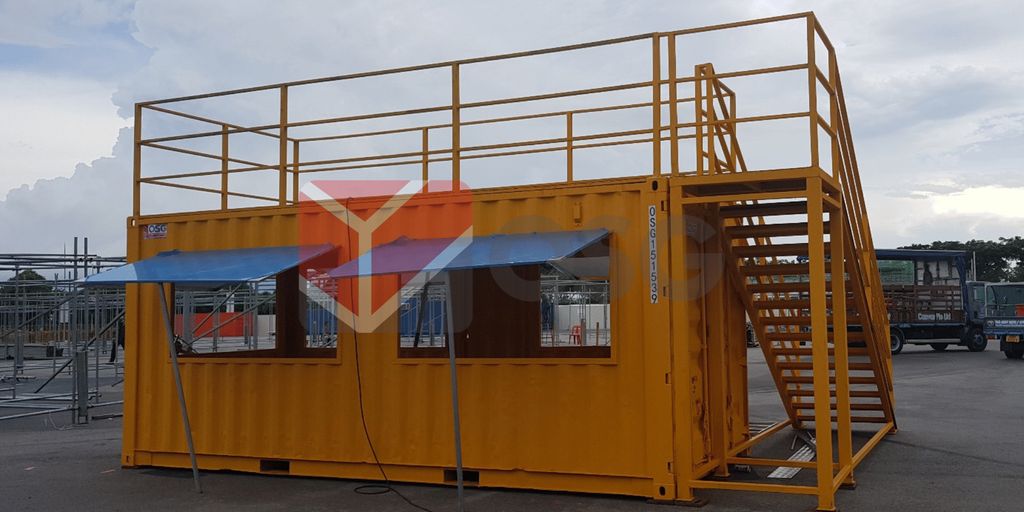 A yellow shipping container converted into a two-story structure.