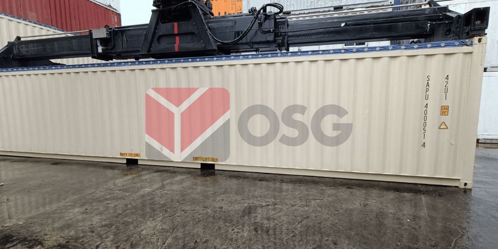 Shipping container with a crane overhead in a storage area.