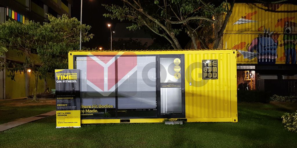 Colorful shipping container gym with fitness promotion and greenery.