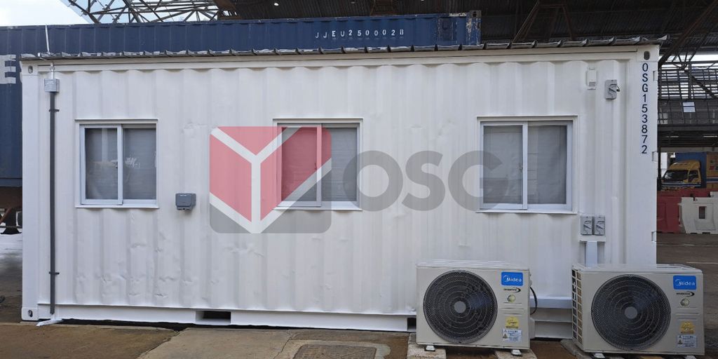 A white shipping container with windows and air conditioning units.