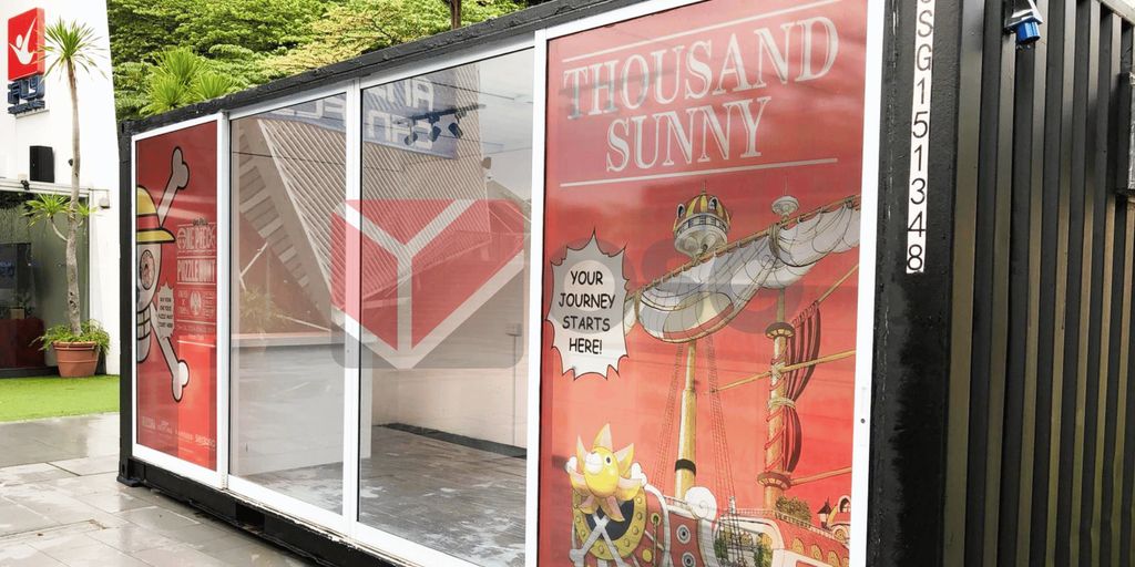 A shipping container with vibrant graphics of a ship and text.