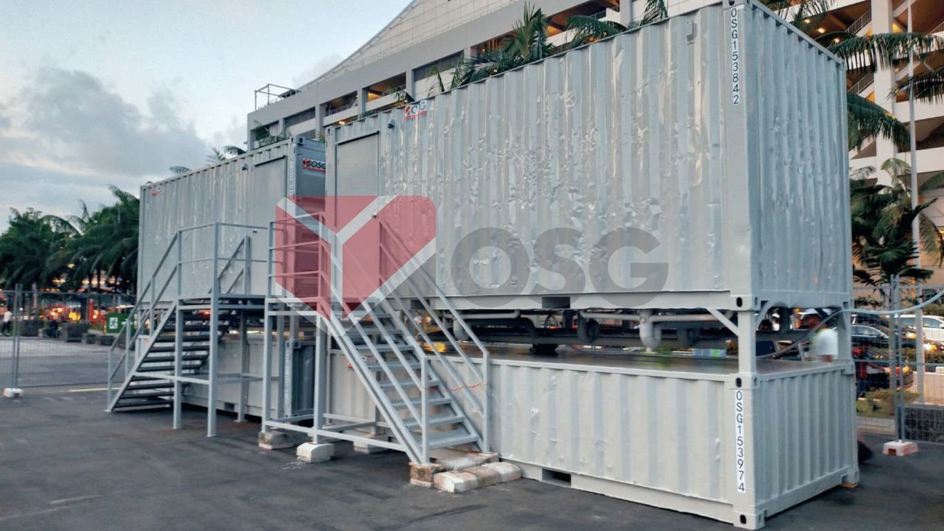 Industrial shipping containers with stairs, set up outdoors.