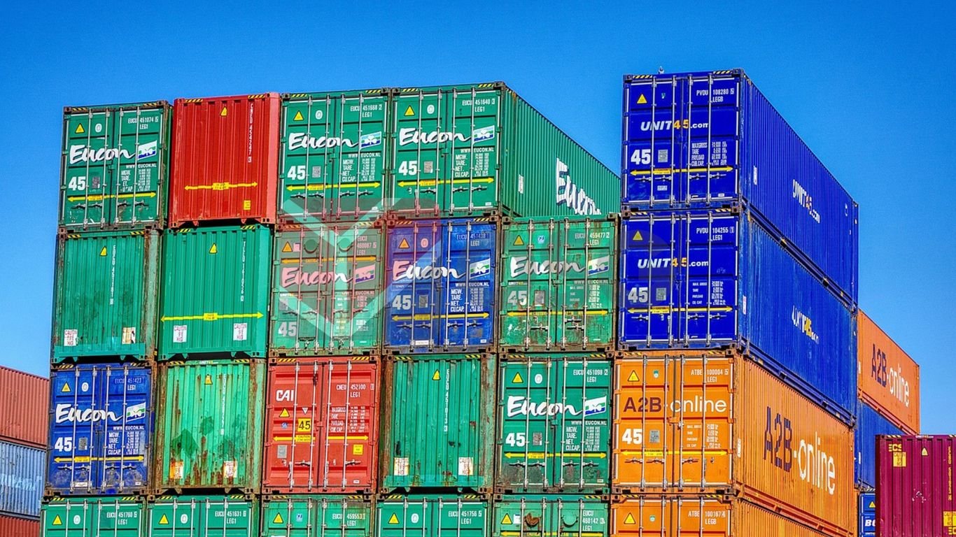 Colorful shipping containers stacked against a clear blue sky.