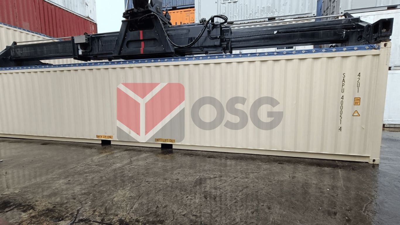 Shipping container with a crane overhead in a storage area.