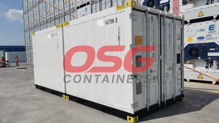 White shipping containers stacked in a yard with a logo.