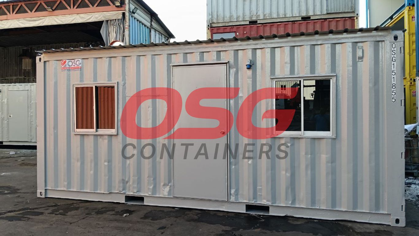 A portable container office with windows and a door.