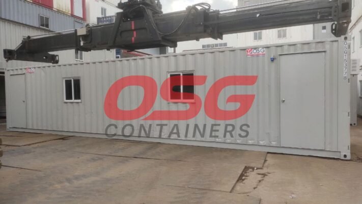 A crane lifts a shipping container with OSG Containers logo.