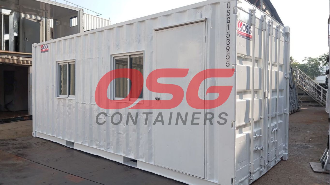 A white shipping container modified into a small office or room.