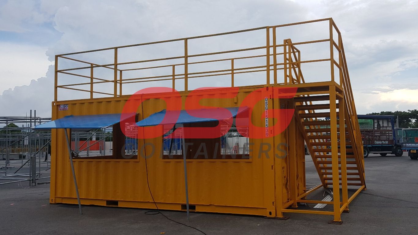Yellow shipping container converted into a temporary structure with stairs.