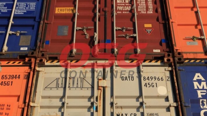 Stacked shipping containers in various colors at a port.