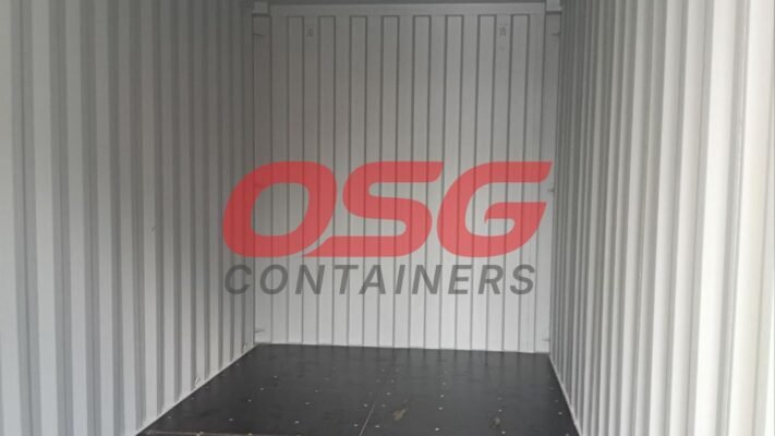 Interior of an empty shipping container with OSG Containers logo.