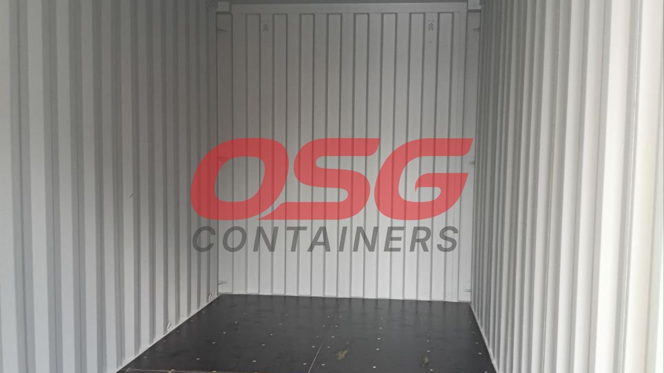 Interior of an empty shipping container with OSG Containers logo.