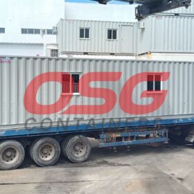 A long container is loaded onto a truck for transport.