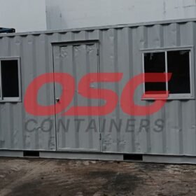 A gray shipping container modified into a small office space.
