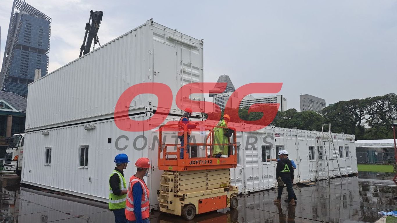 Workers install modular containers with a crane and lift.