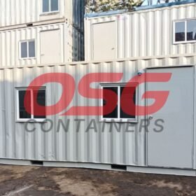 Stacked shipping containers with windows and doors, some with logos.