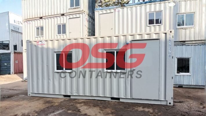Stacked shipping containers with windows and doors, some with logos.