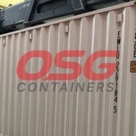 Shipping containers stacked at a yard with a crane overhead.