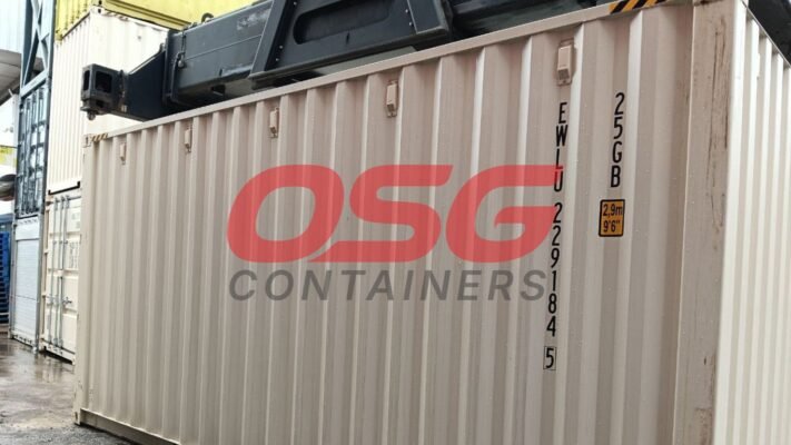 Shipping containers stacked at a yard with a crane overhead.