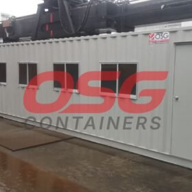 A grey modular container office with windows and a door.