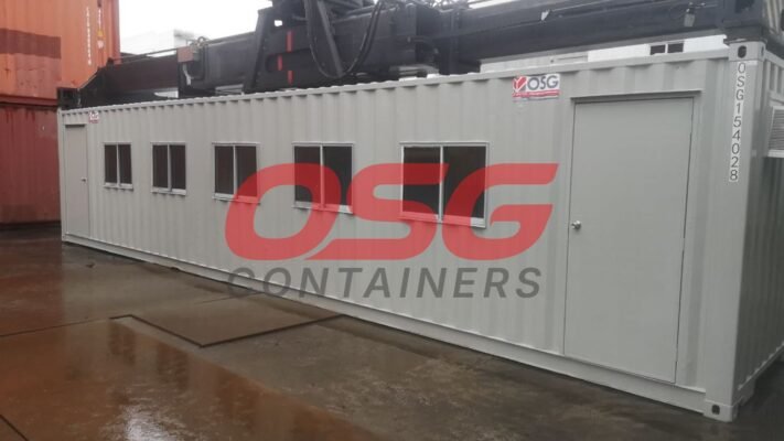 A grey modular container office with windows and a door.