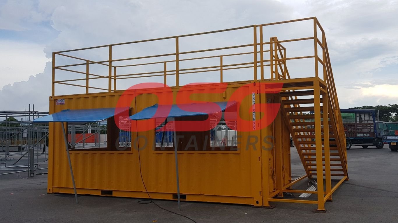 Yellow shipping container converted into a temporary structure with stairs.
