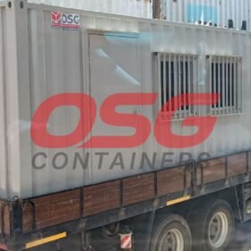 A portable container office is loaded onto a truck.