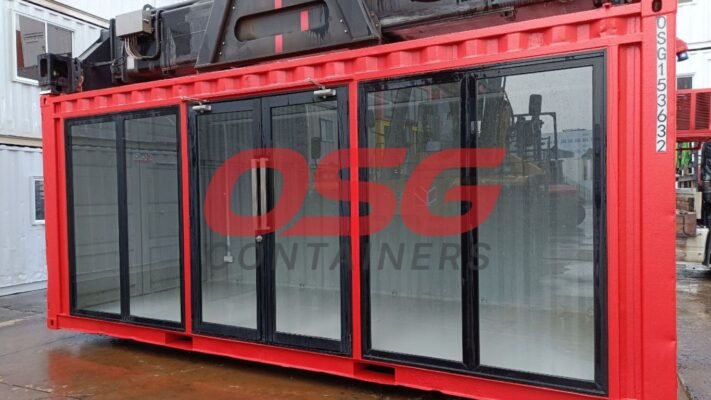 Red shipping container with large glass doors and windows.