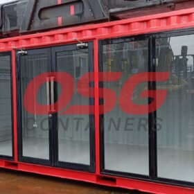Red shipping container with large glass doors and windows.