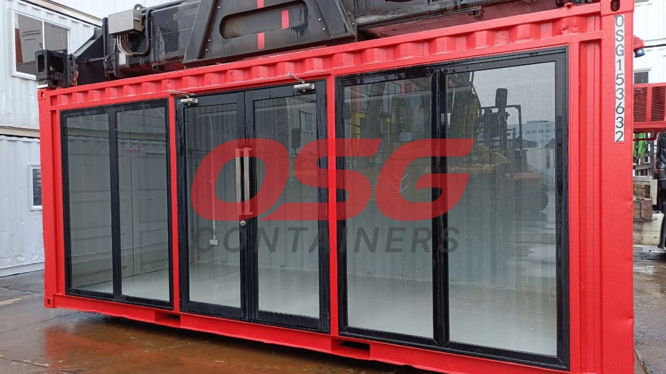 Red shipping container with large glass doors and windows.