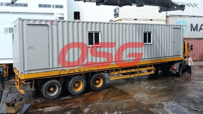 A container office unit is being loaded onto a truck.