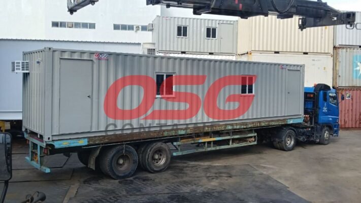 A container office is loaded onto a truck for transport.