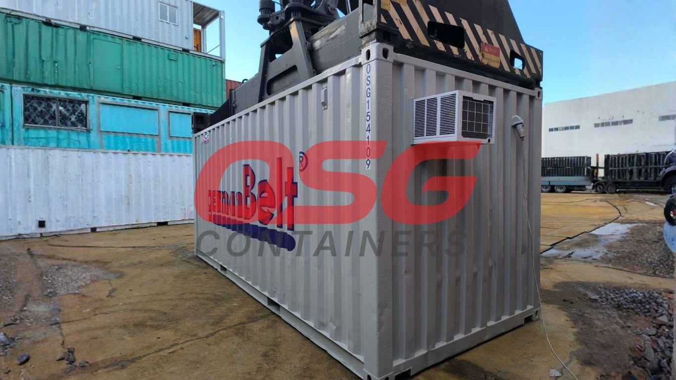 A shipping container with an air conditioner is being lifted.