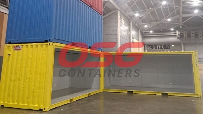 Stacked shipping containers, one open, in a warehouse.