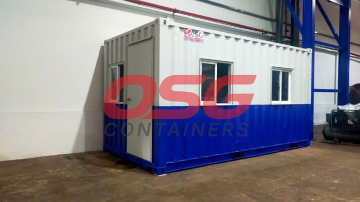 A blue and white shipping container office with windows and a door.