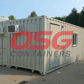 A long, light gray shipping container office with windows and air conditioners.