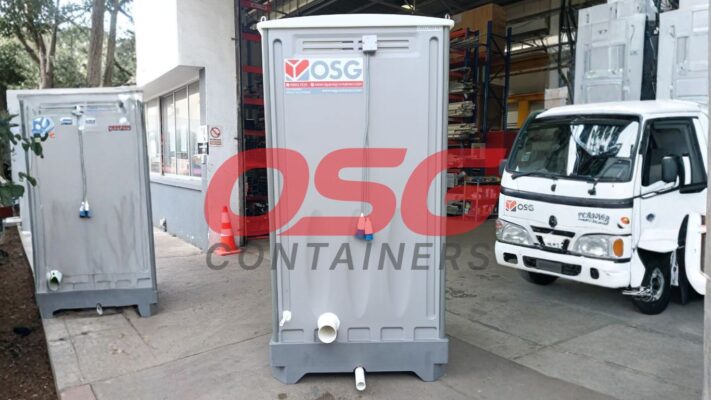 Portable toilets and a delivery truck are parked outside.