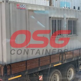 A portable container office is loaded onto a truck.