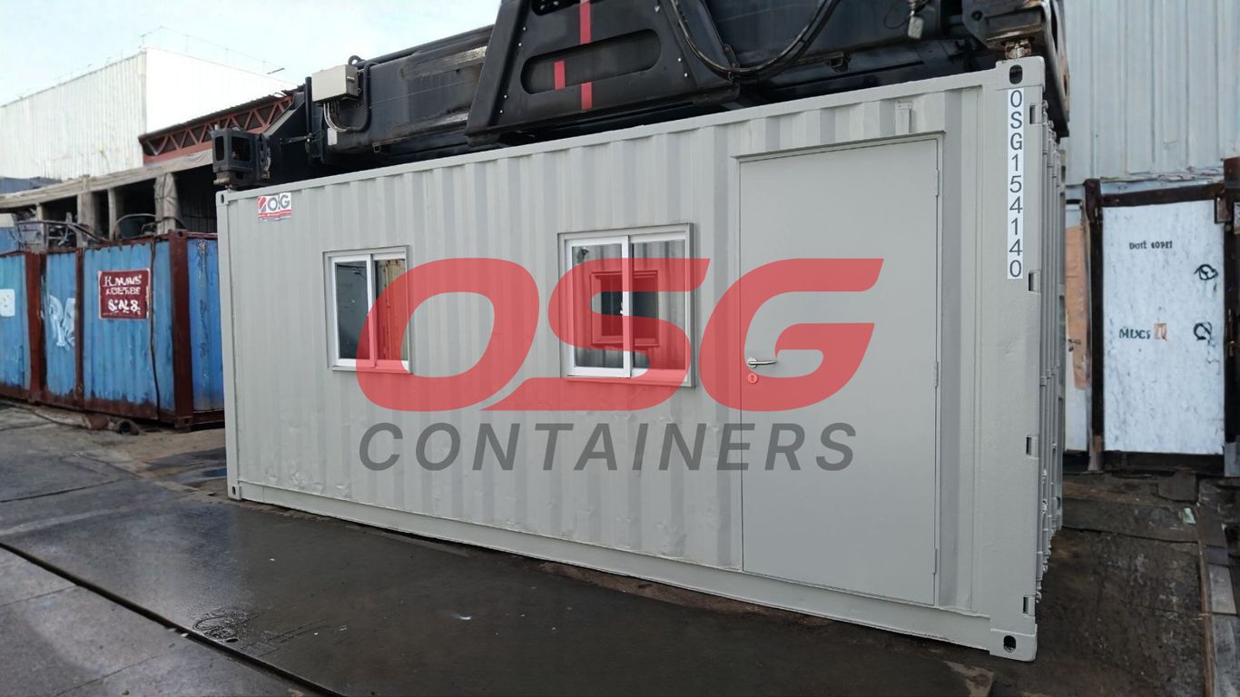 A light gray shipping container office with windows and a door.