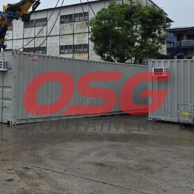Crane lifting shipping containers at a facility.