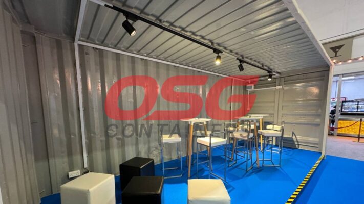 Modern bar setup inside a shipping container with seating.
