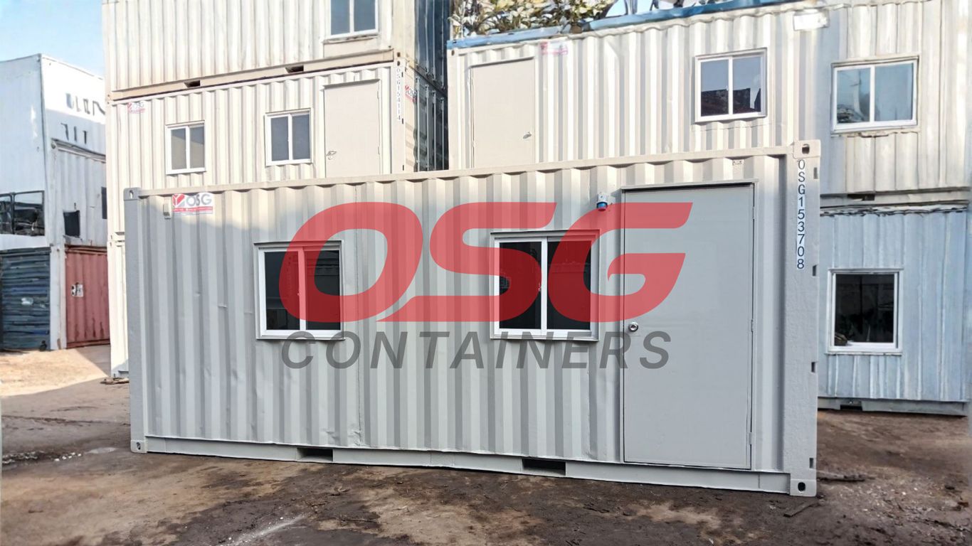 Stacked shipping containers with windows and doors, some with logos.