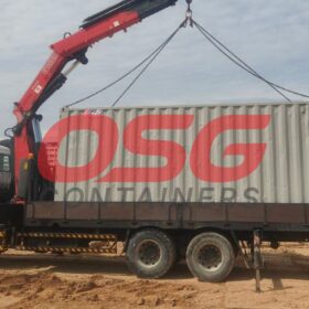 Crane truck loading a shipping container with OSG Containers logo.