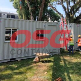 Construction site with modular containers and workers.