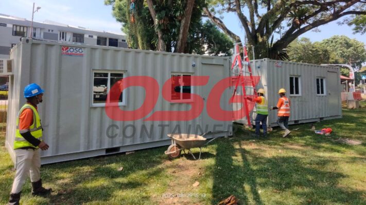 Construction site with modular containers and workers.