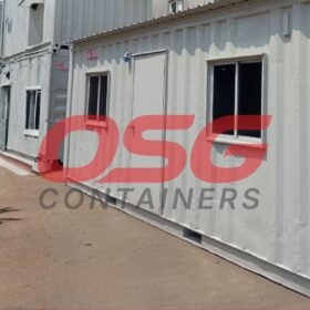 Row of modular shipping container offices with windows and doors.