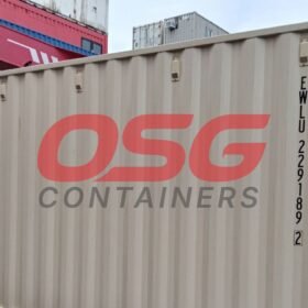 OSG containers stacked in a yard with a crane overhead.